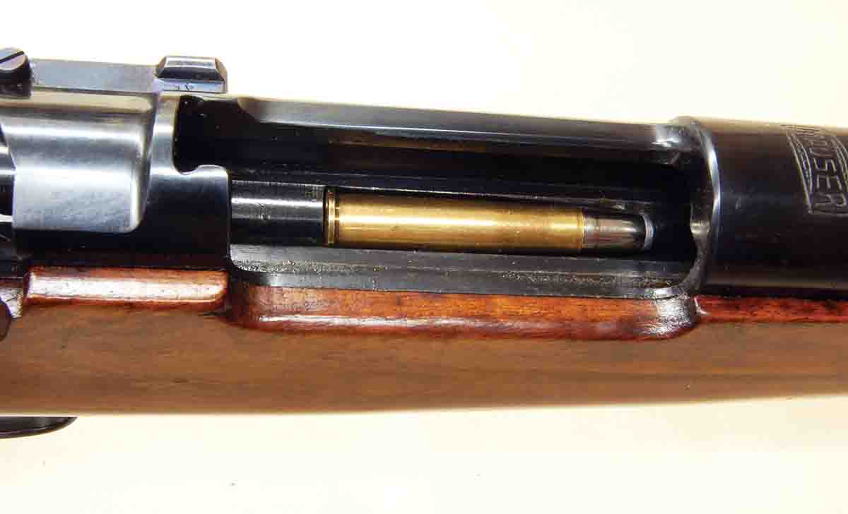 An 8.15x46R cartridge is laying in the recess milled into the solid bottom of the receiver. Note there is also no thumb cut.